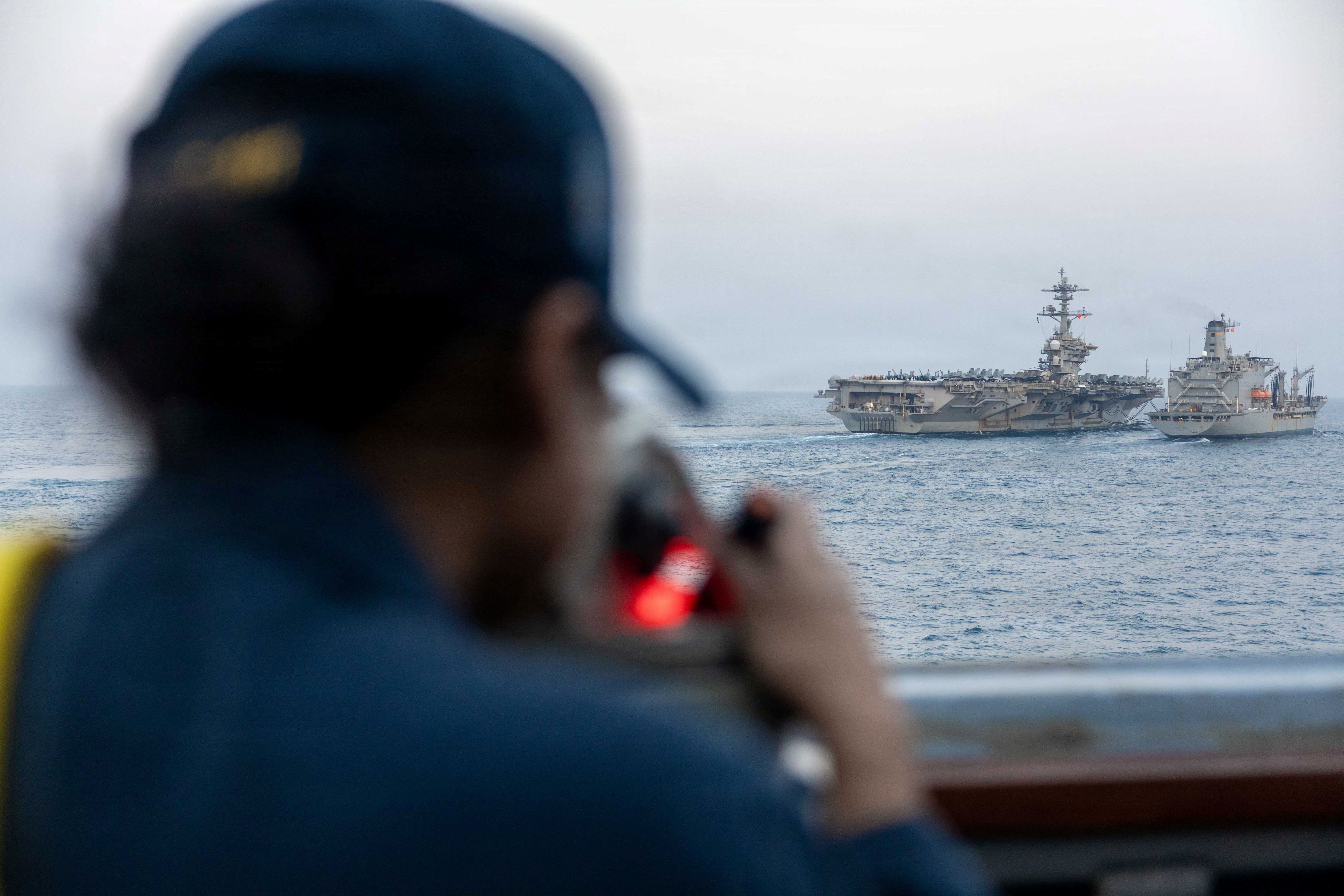 Navy sailor looks out at Nimitz-class aircraft carrier USS Abraham Lincoln