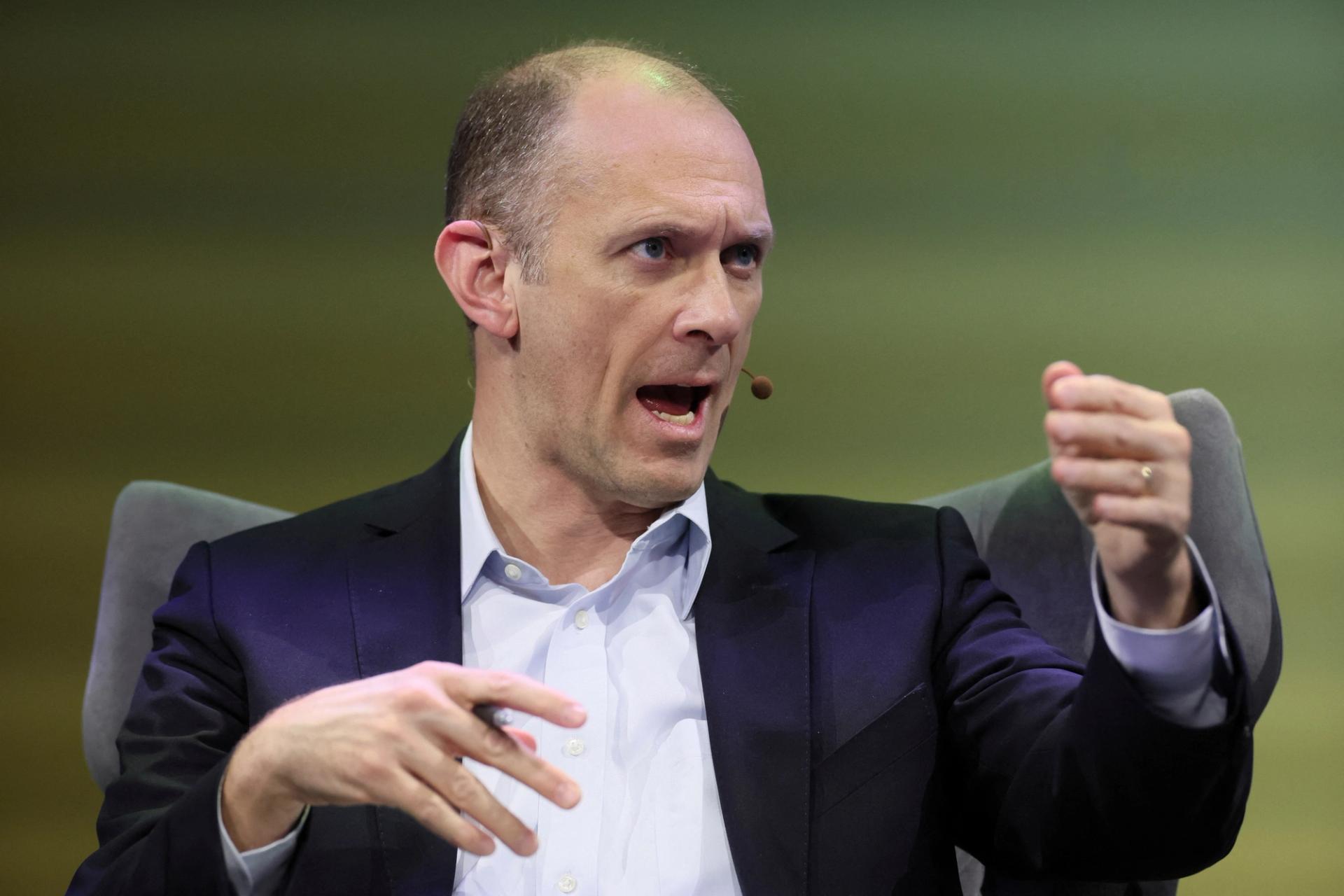 Austan Goolsbee, a bald, white man wearing a navy suit, gesturing with his hands at a conference in New York City