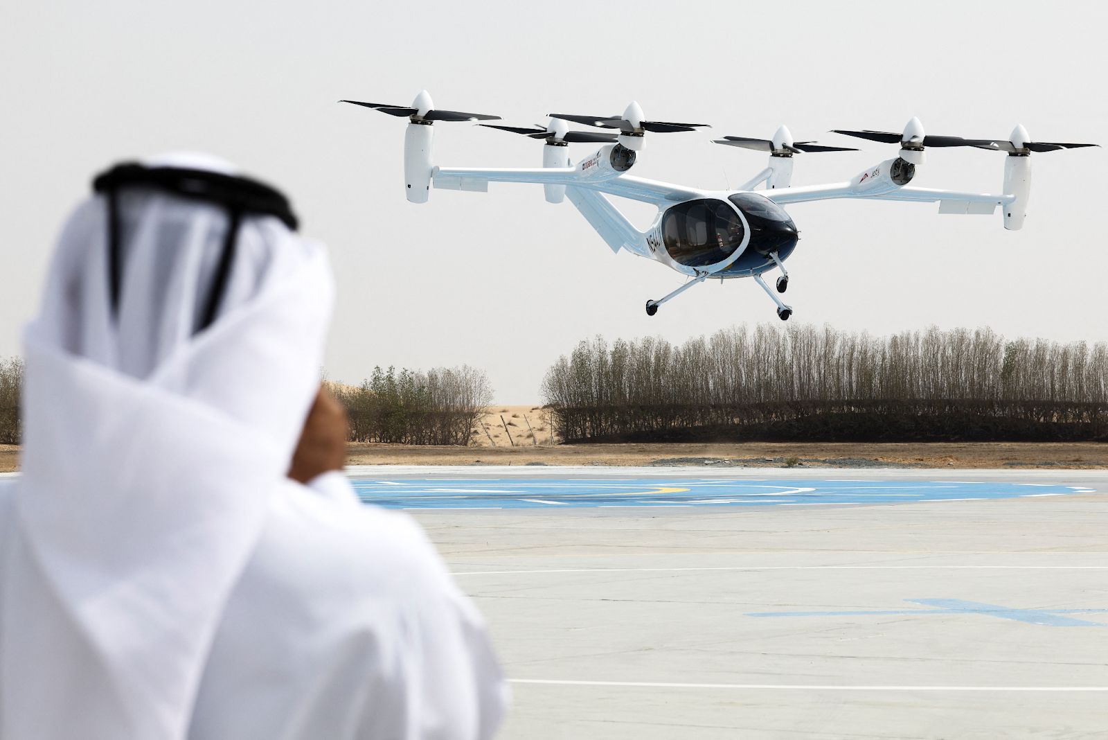 A bystander watches a test flight of a Joby aircraft taking off in Dubai on June 30, 2025.