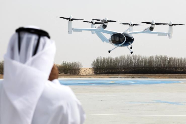 A bystander watches a test flight of a Joby aircraft taking off in Dubai on June 30, 2025.