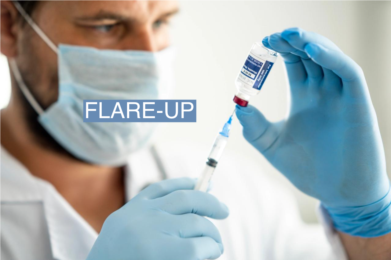 Close up of a medical professional holding a syringe drawing vaccine from a vial to prepare for injection.