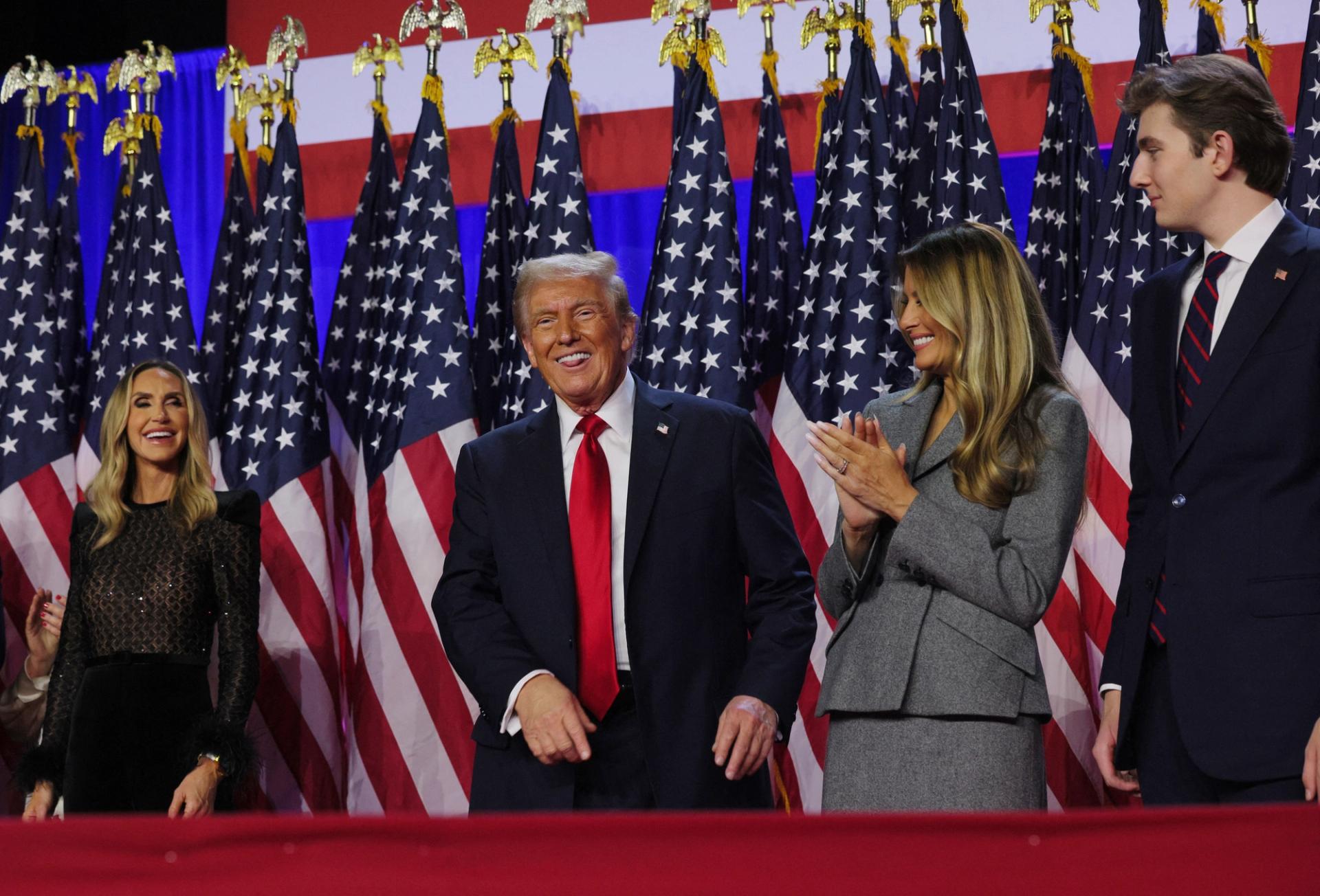 Former U.S. President Donald Trump smiles while accompanied by his wife Melania, Lara Trump and son Barron.