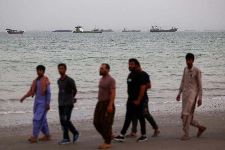 Men walk on the beach in Bandar Abbas, Iran