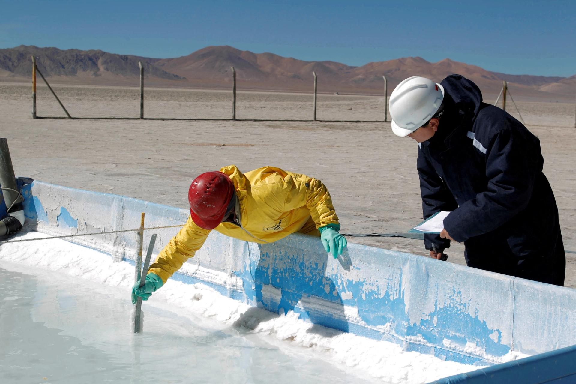 Technicians from the Orocobre mining company work on an evaporation pond test in the salt flat at Olaroz, north of the Argentinian province of San Salvador de Jujuy