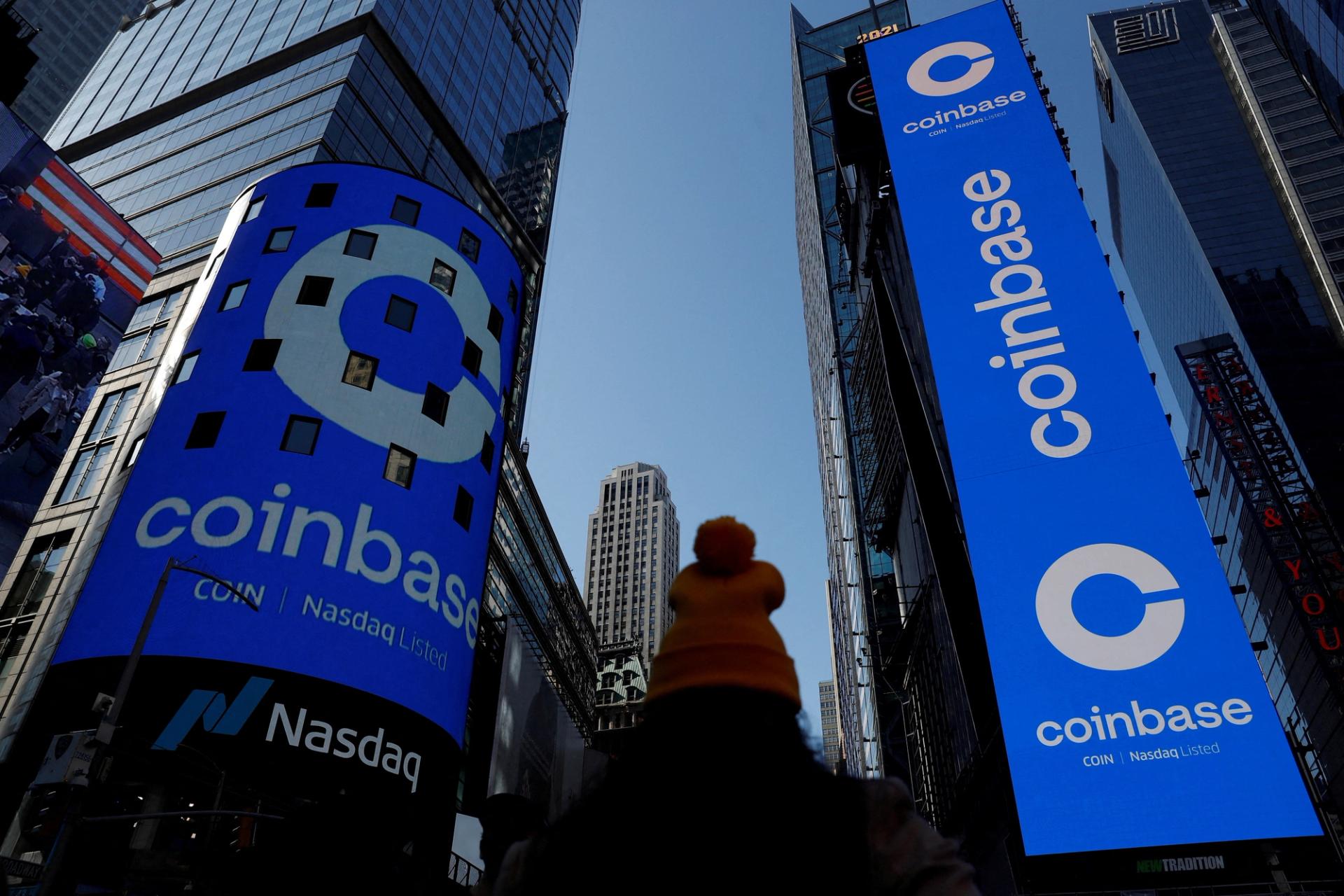 The logo for Coinbase Global Inc is displayed on the Nasdaq MarketSite jumbotron and others at Times Square in New York, 2021.