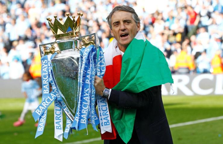 Wrapped in the UAE flag, Manchester City manager Roberto Mancini celebrates winning the Barclays Premier League.