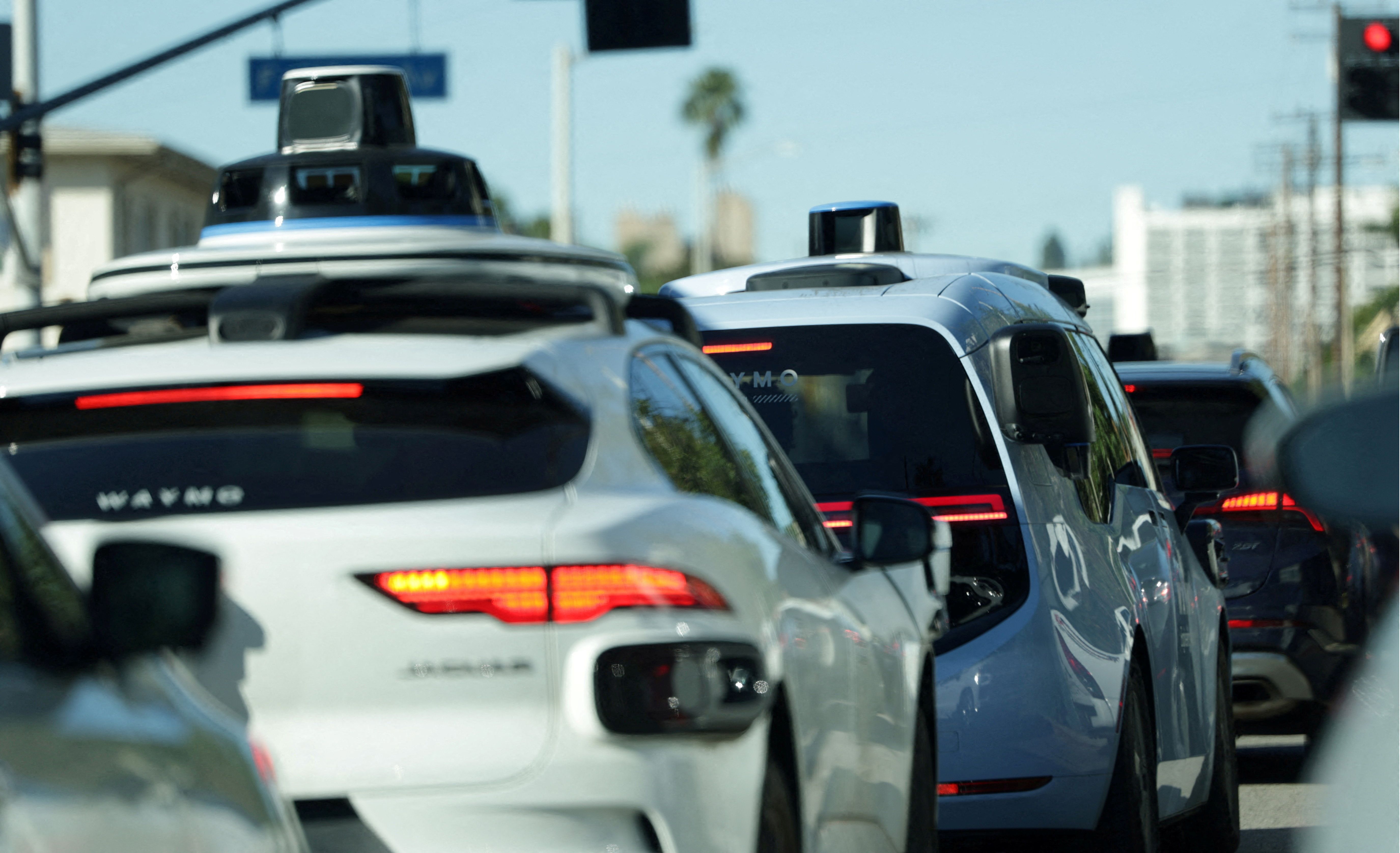 Waymo driverless taxis in traffic in Los Angeles.