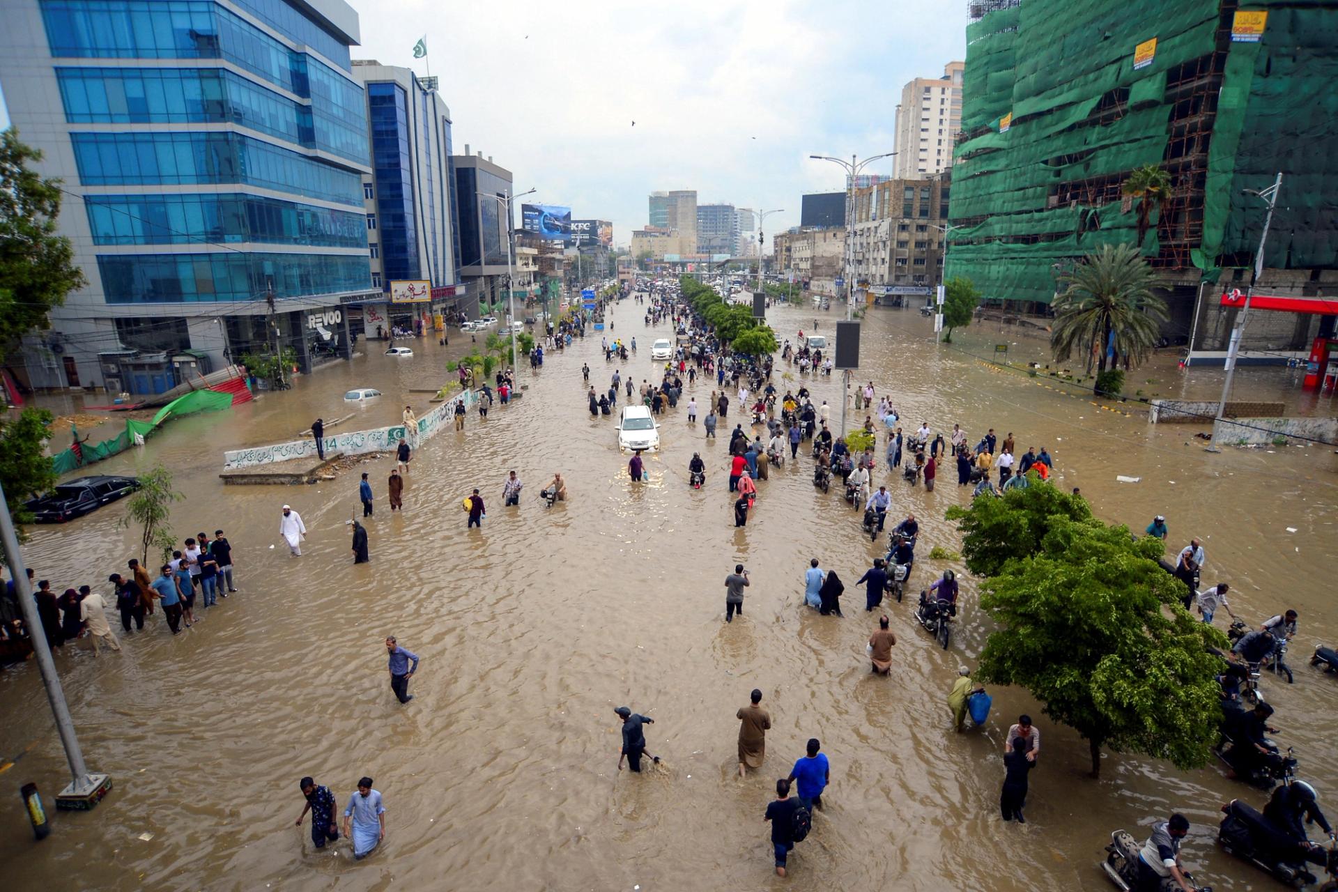 People wade through a flooded road after the monsoon rain in Karachi, Pakistan.