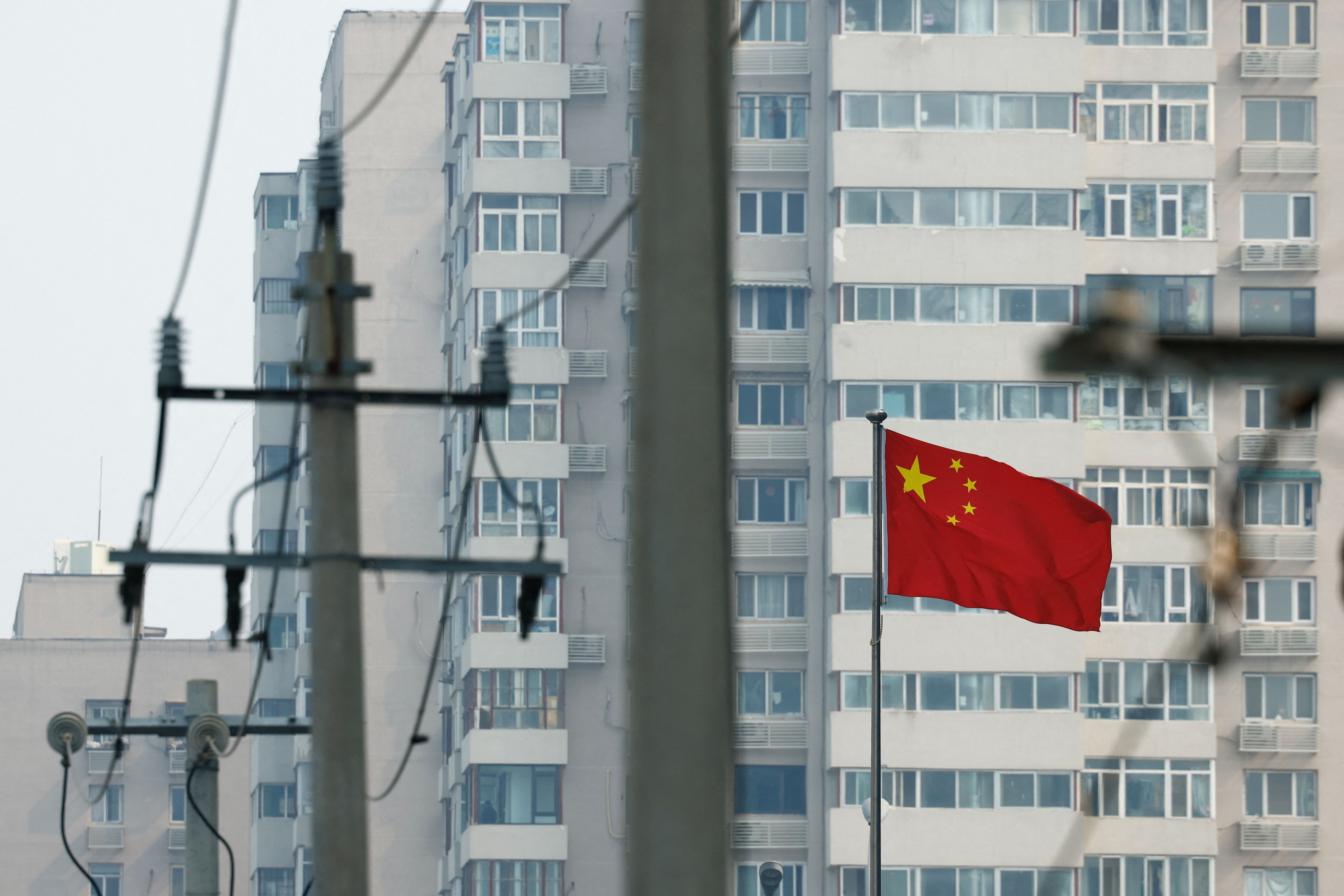 A Chinese national flag flutters near residential buildings in Beijing.