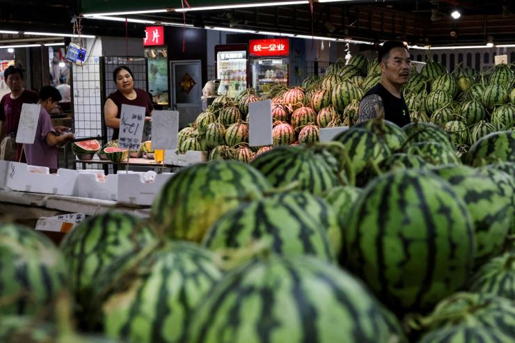 People shop at a wet market in Shanghai, China
