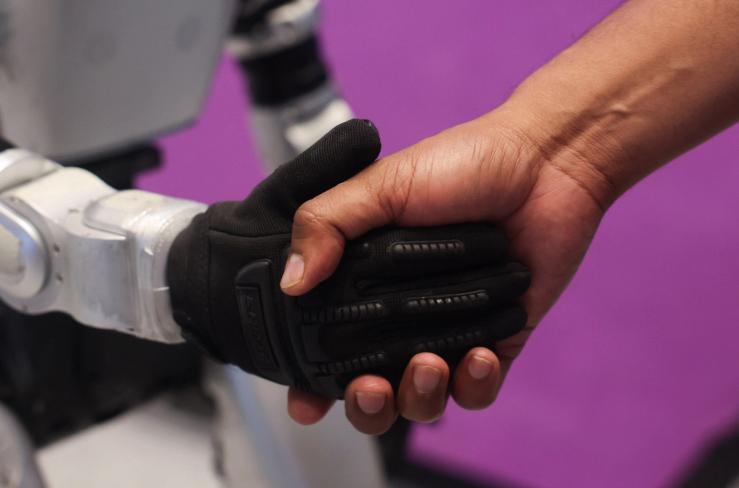 A man shakes the hand of a Chinese G1 humanoid robot.