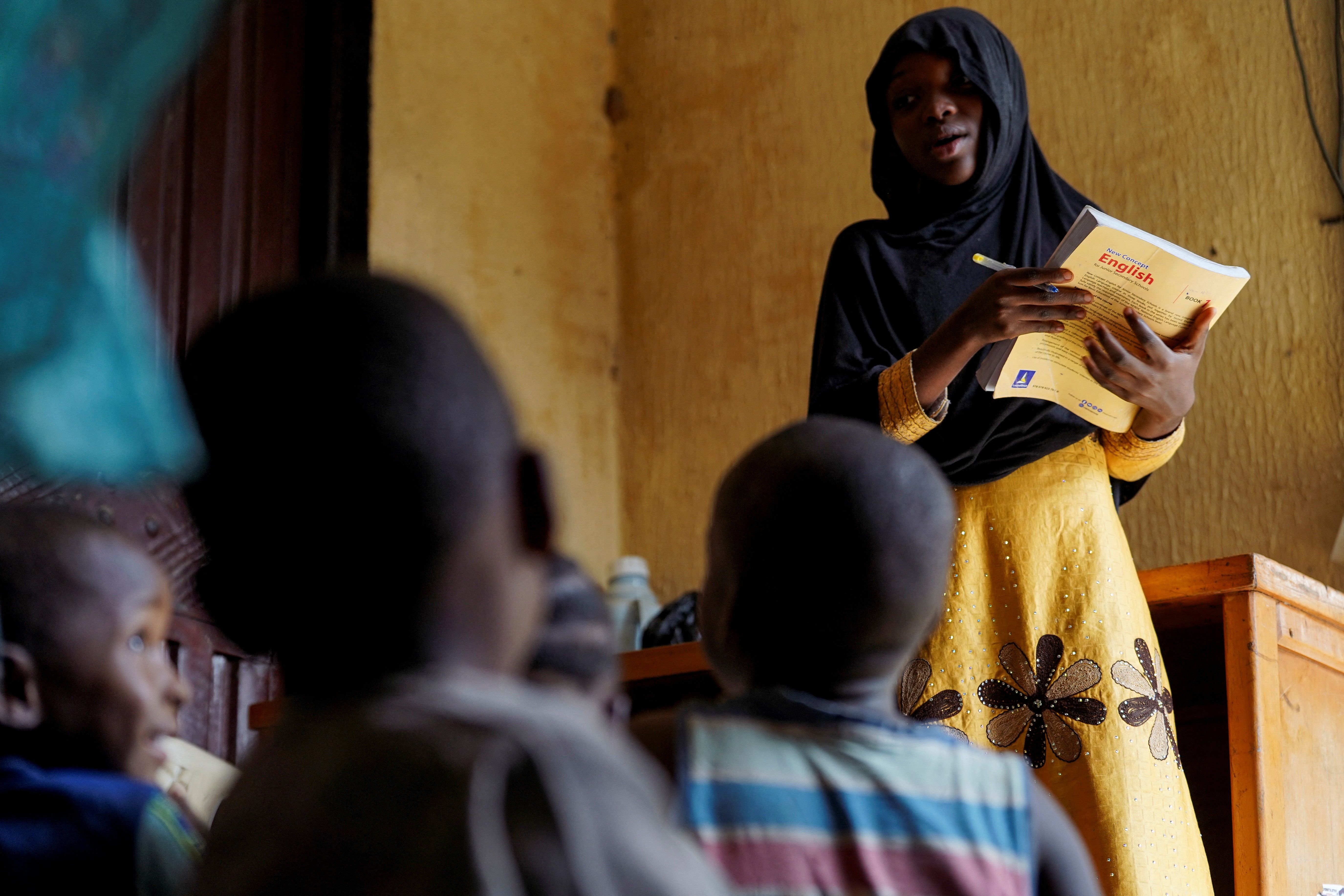 Nana Aisha Shemsudeen teaches her younger siblings and neighbors at her parents’ house in Minna.