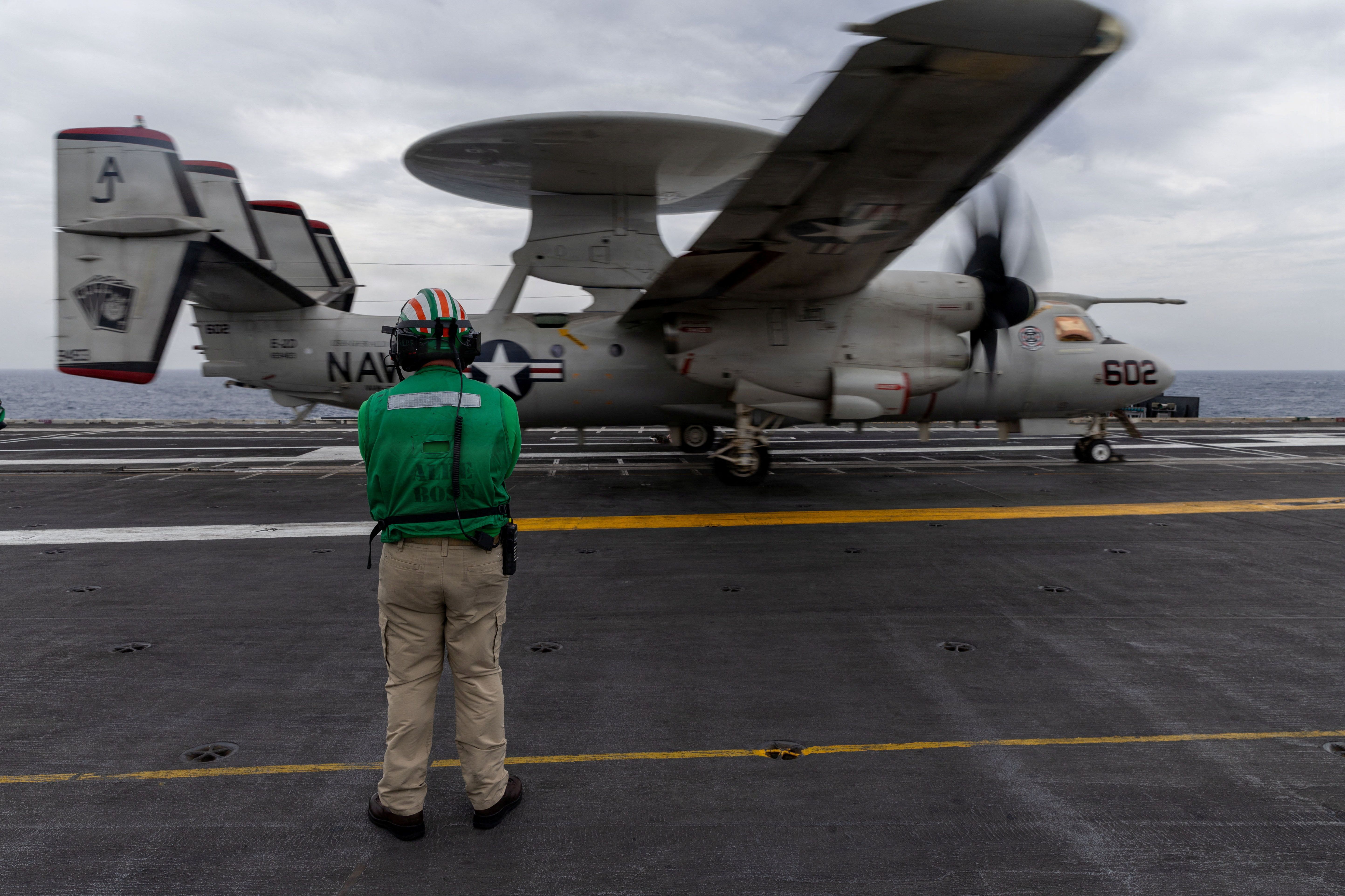 A U.S. sailor observes the launch of an E-2D Hawkeye aircraft on the flight deck of the aircraft carrier USS Gerald R. Ford during the Operation Epic Fury attack on Iran 