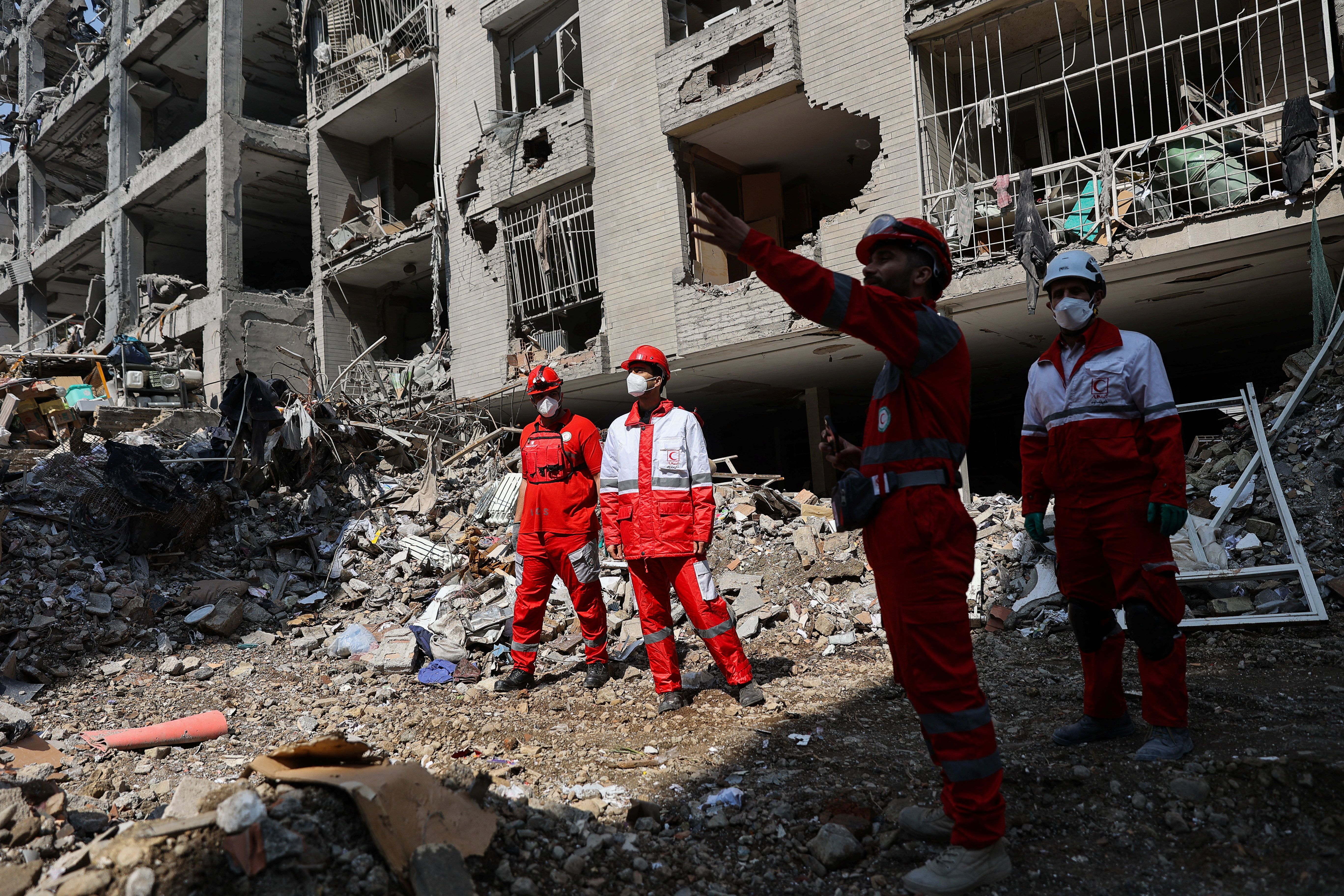 Members of a Red Crescent rescue team work at a building that was damaged by a strike