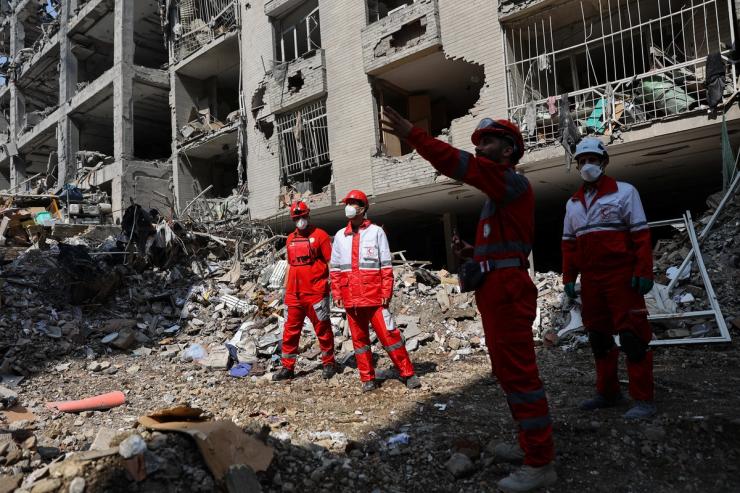 Members of a Red Crescent rescue team work at a building that was damaged by a strike
