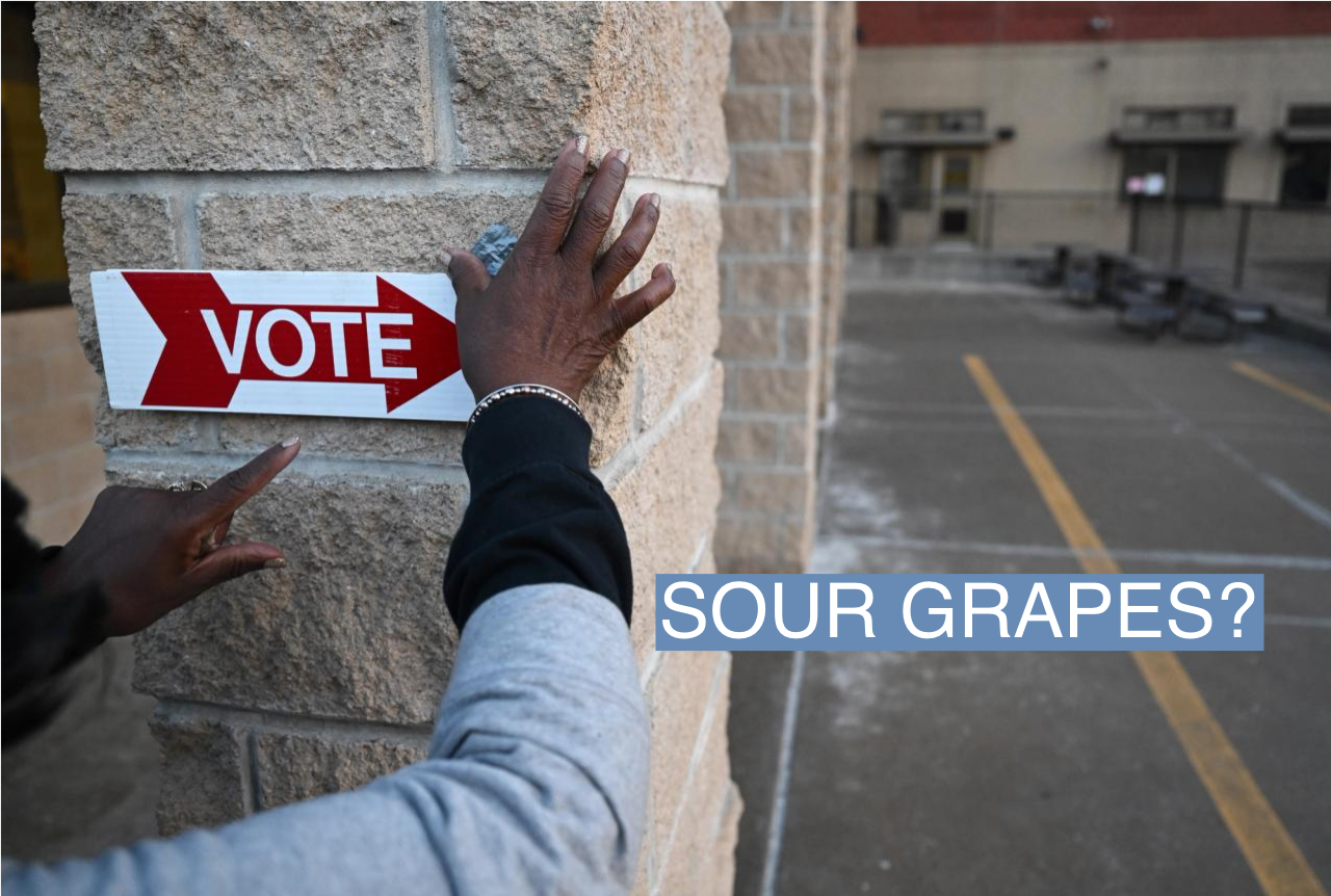 An election worker puts up a sign to direct voters for the Michigan primary election on Feb. 27, 2024, in Grand Rapids, Mich.