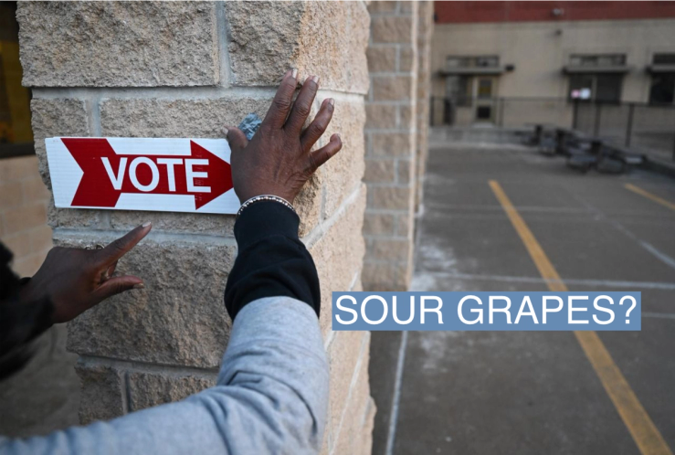 An election worker puts up a sign to direct voters for the Michigan primary election on Feb. 27, 2024, in Grand Rapids, Mich.