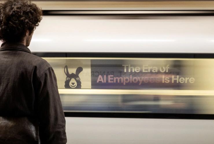 A London underground train passes a billboard for an Artificial Intelligence company advertising AI employees in London.