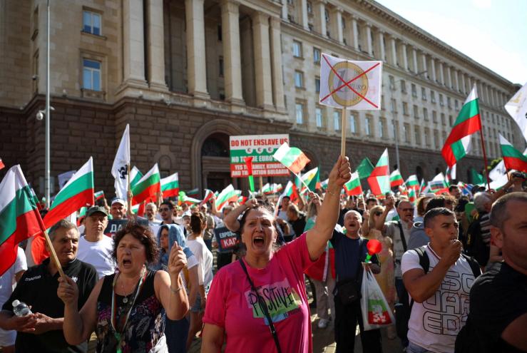 Protesters hold banners and flags as they participate in a demonstration, organised by Bulgaria’s ultranationalist Revival party.