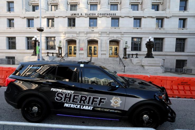 A sheriff’s vehicle passes by the Lewis R. Slaton Courthouse and Superior Court of Fulton County.