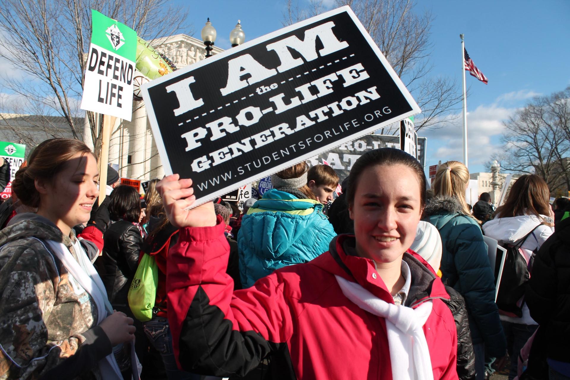 Girl holds a sign in a protest saying “I am the pro-life generation”