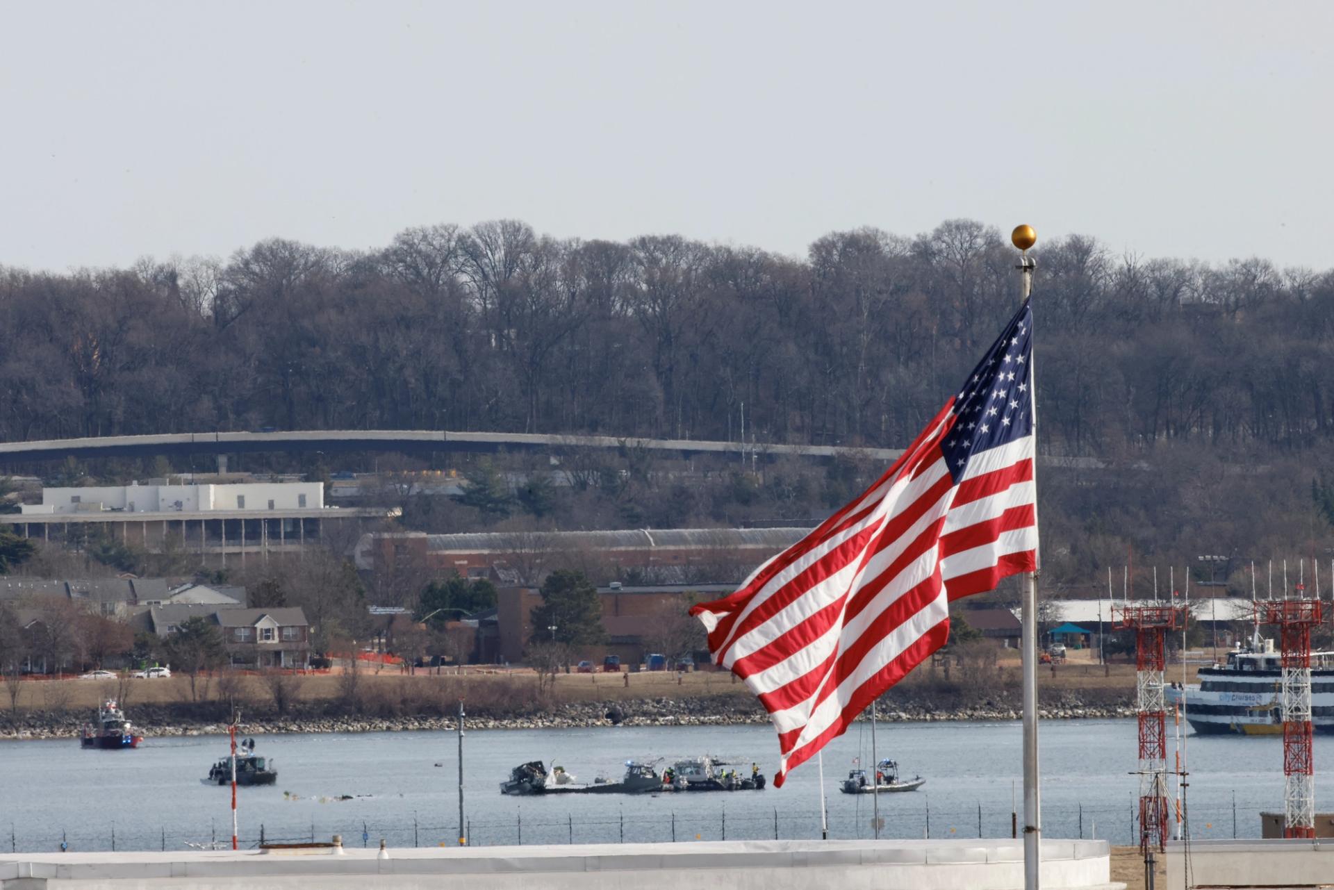 Search and rescue teams work at the crash site at DCA airport