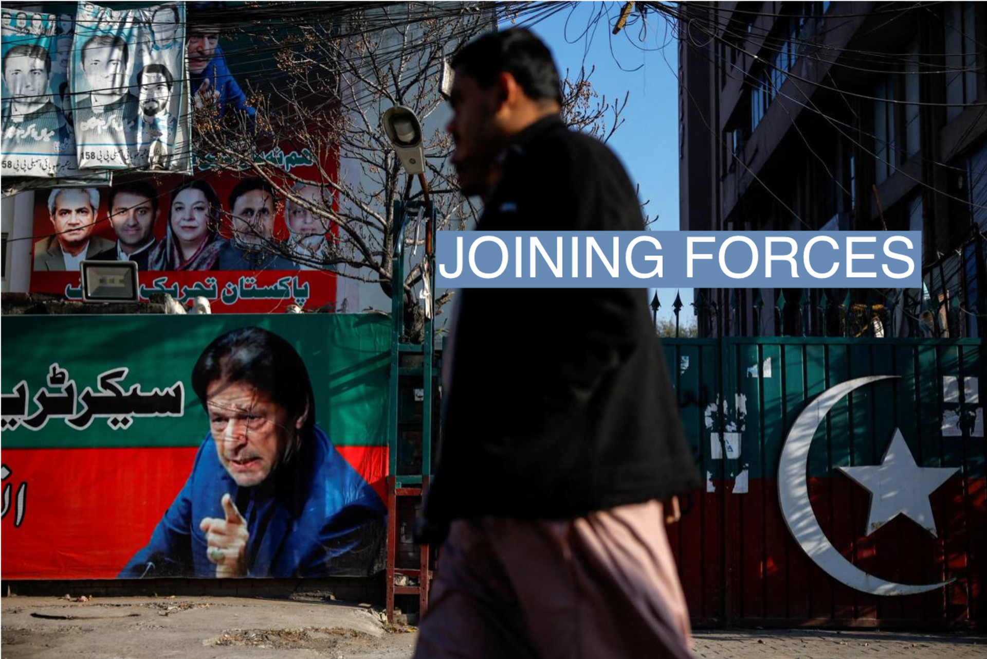 People walk past a banner with a picture of the former Prime Minister Imran Khan outside the party office of Pakistan Tehreek-e-Insaf (PTI), a day after the general election, in Lahore, Pakistan, February 9, 2024. REUTERS/Navesh Chitrakar//File Photo