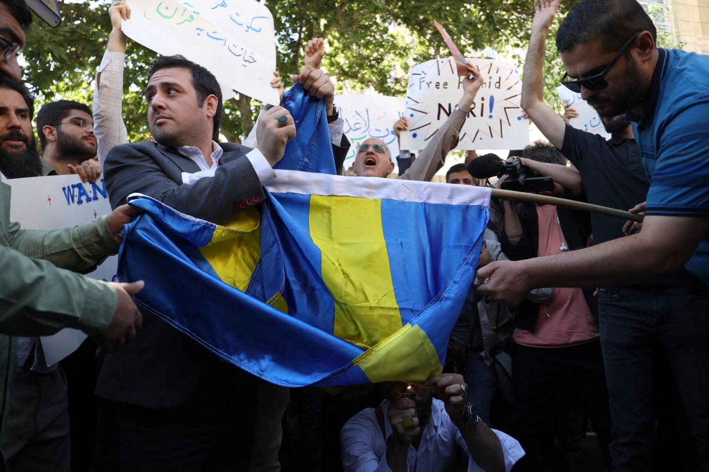 Demonstrators burn the Swedish flag during a protest against a man who burned a copy of the Quran outside a mosque in the Swedish capital Stockholm, in front of the Swedish Embassy in Tehran.