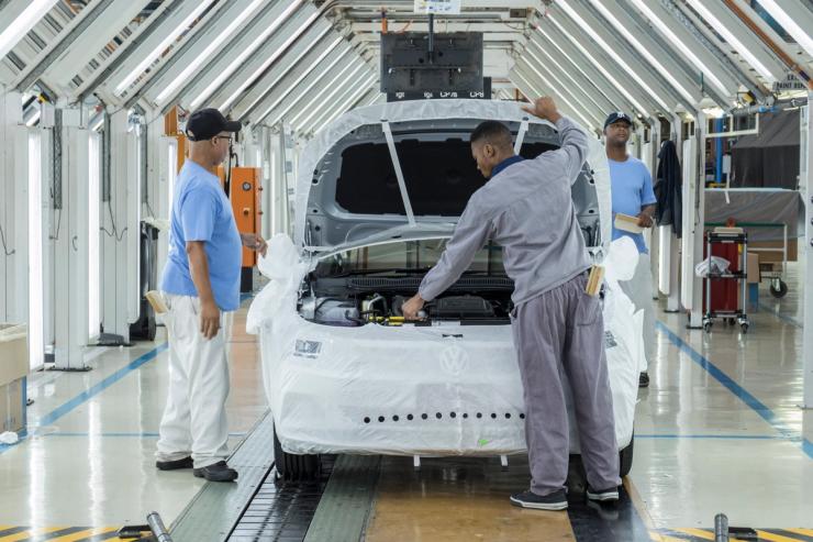 Employees work on manufacturing a car at a Volkswagen plant, South Africa.