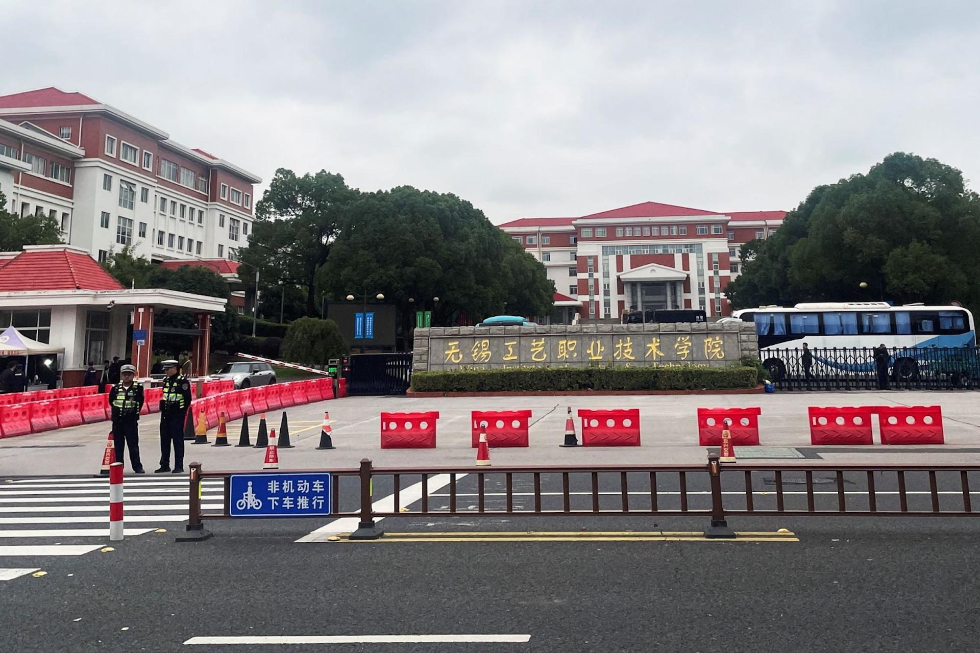 Police officers keep watch near an entrance to the Wuxi Vocational College of Arts and Technology following a knife attack, in Wuxi.