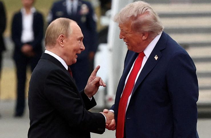 President Donald Trump shakes hands with Russia’s Vladimir Putin