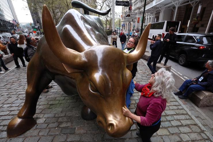 Members of the climate activist group Extinction Rebellion clean up after vandalizing the Charging Bull, as part of an “Earth Day” protest against Wall Street’s alleged complicitness in climate change, in New York City, U.S.