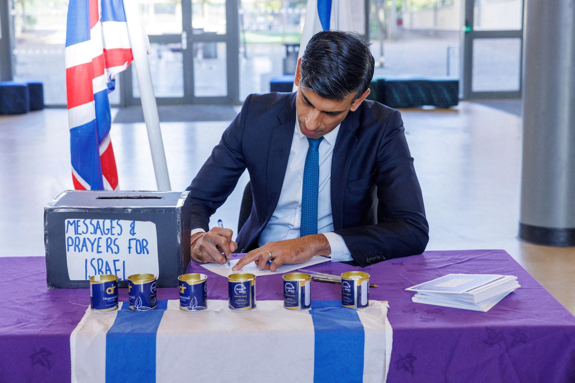 British Prime Minister Rishi Sunak signs messages and prayers for Israel at a Jewish school in London, Britain October 16, 2023. 