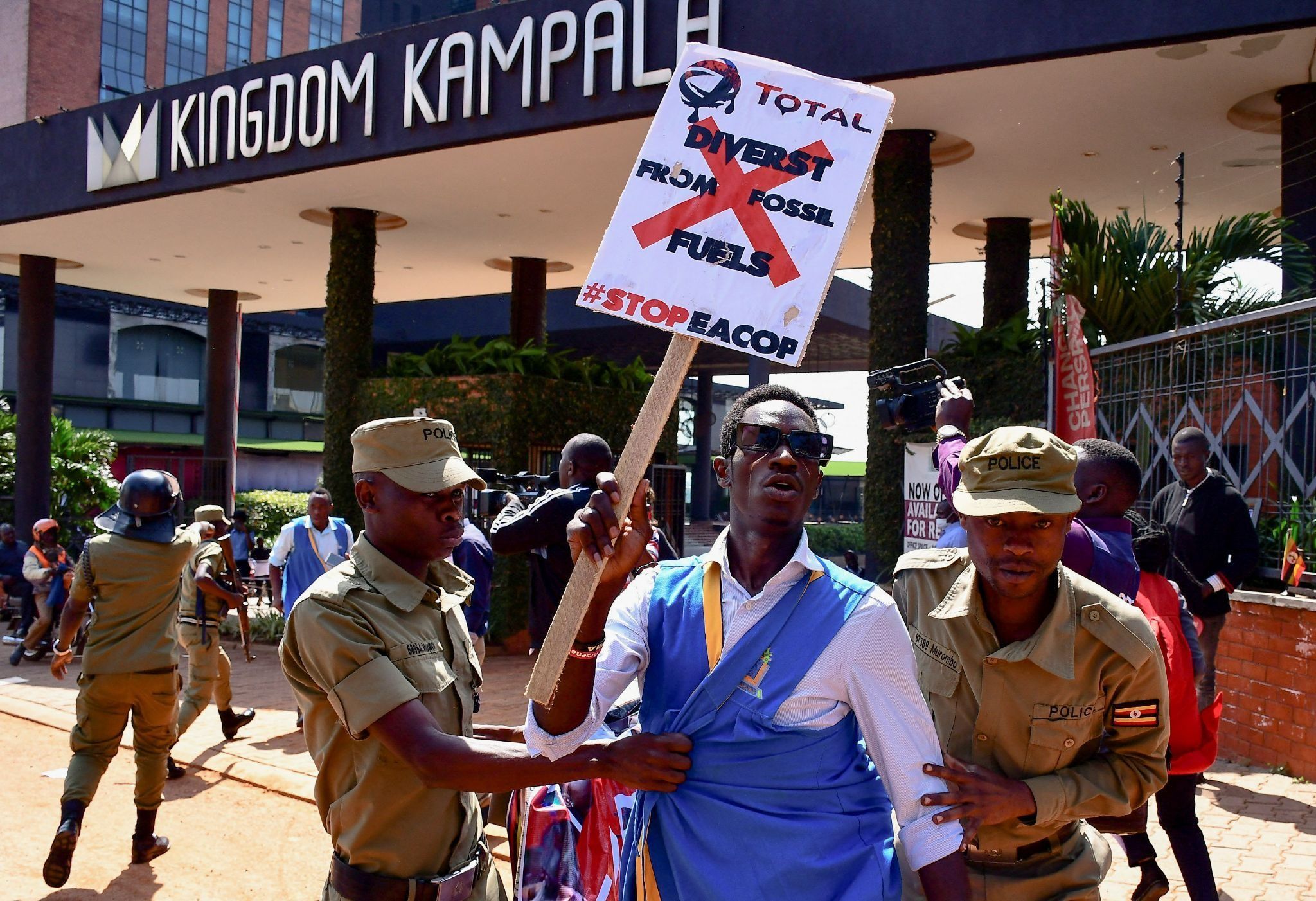 Ugandan riot police officers detain an activist during a march in support of the European Parliament resolution to stop the construction of the East African Crude Oil Pipeline.