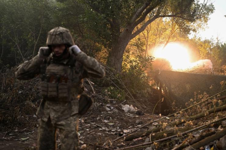 Ukrainian servicemen fire a self-propelled howitzer towards Russian troops.