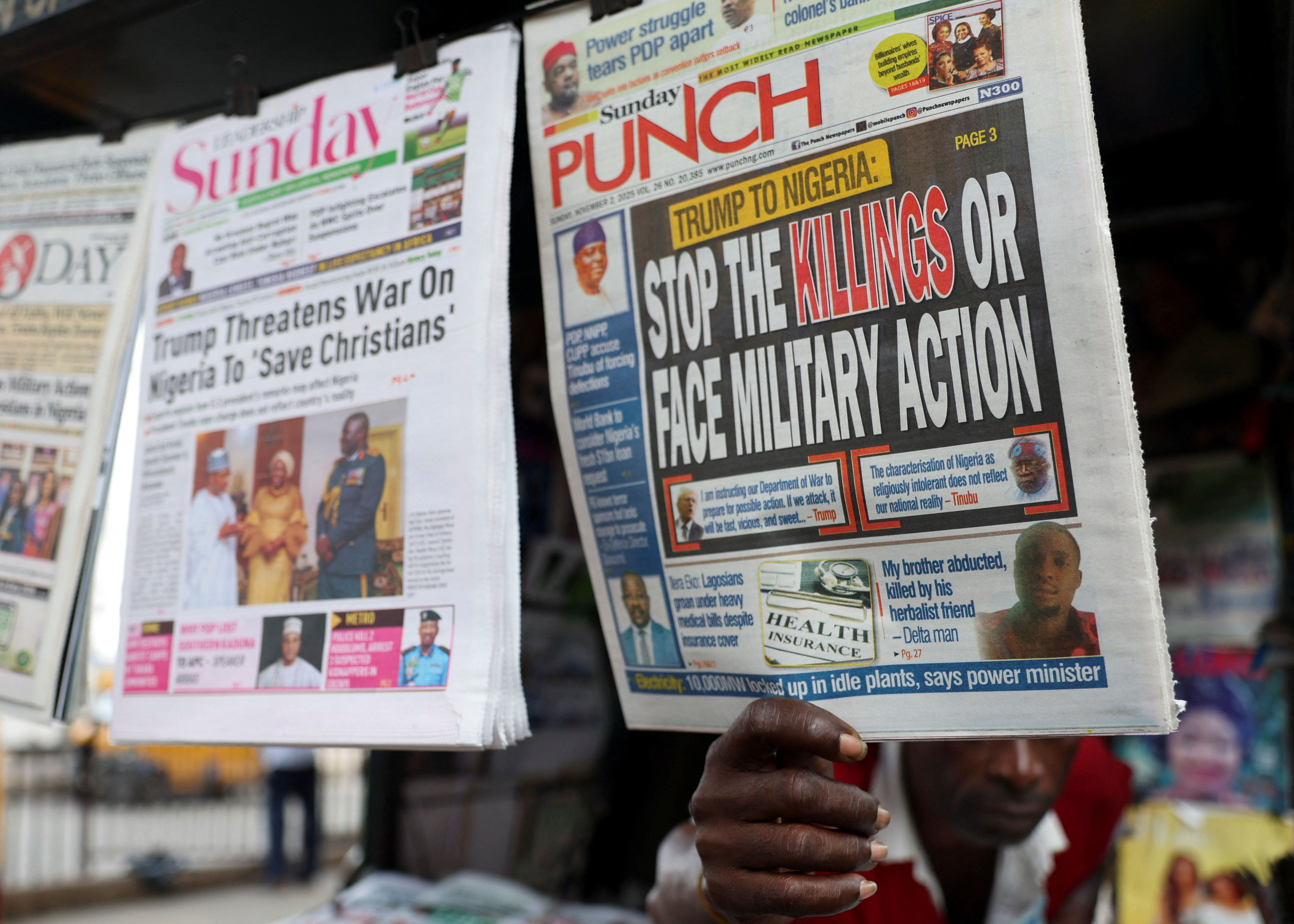 A newspaper vendor pulls a newspaper.