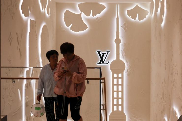 People walk in front of the new Louis Vuitton store in Shanghai, China.