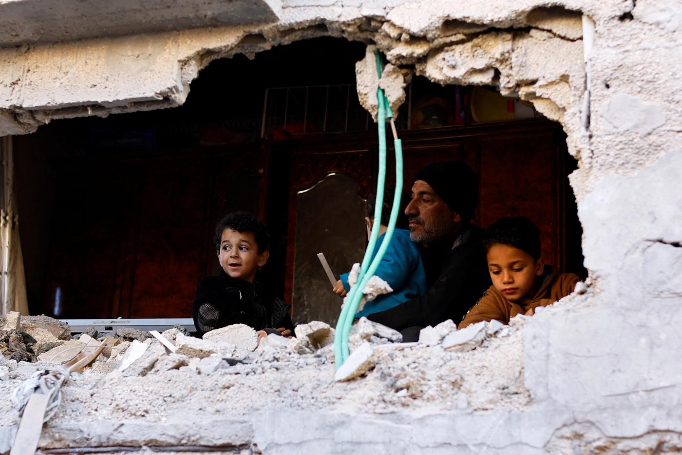 A Palestinian man and children look at the damage at the site of an Israeli strike on a house, amid the ongoing conflict between Israel and the Palestinian Islamist group Hamas, in Rafah in the southern Gaza Strip, February 8, 2024. REUTERS/Ibraheem Abu Mustafa