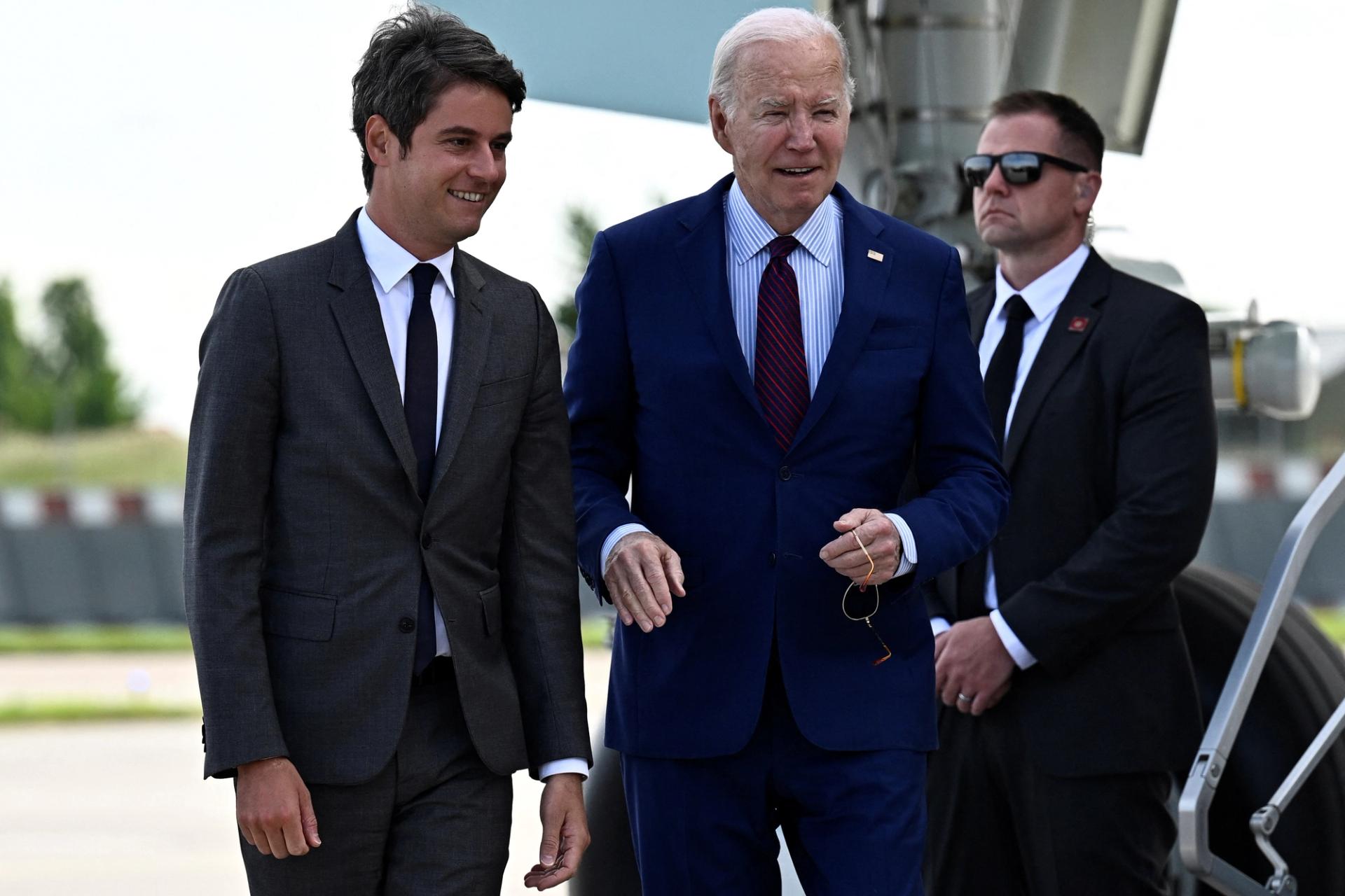 US President Joe Biden (C) is welcomed by France's Prime Minister Gabriel Attal upon arrival at Paris Orly airport near Paris, on June 5, 2024, as he travels to commemorate the 80th anniversary of D-Day. JULIEN DE ROSA/Pool via REUTERS