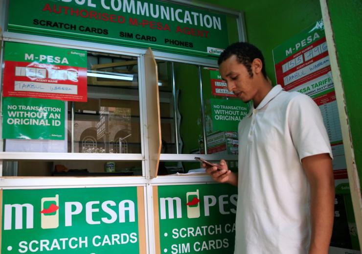 A customer conducts a mobile money transfer, known as M-Pesa, at a Safaricom agent stall.