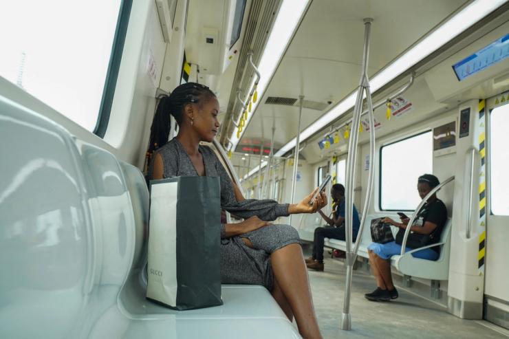 A woman uses her mobile phone as she travels in the Blue Line Rail’s train at Marina Station in Lagos, Nigeria.
