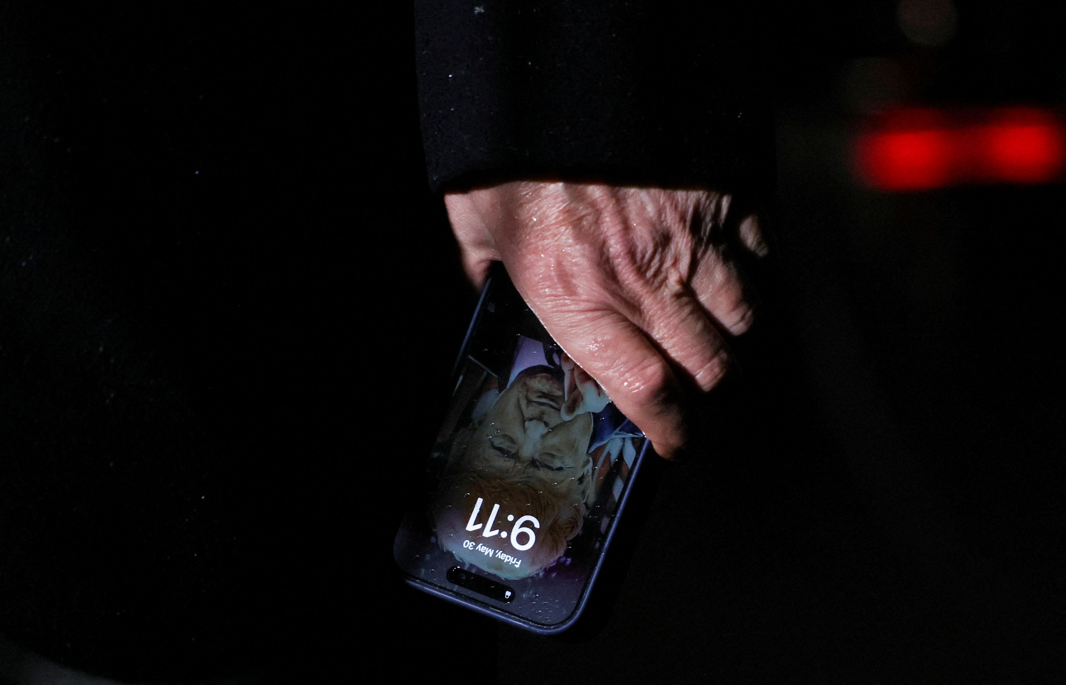 Donald Trump holding a phone with himself on the lock screen