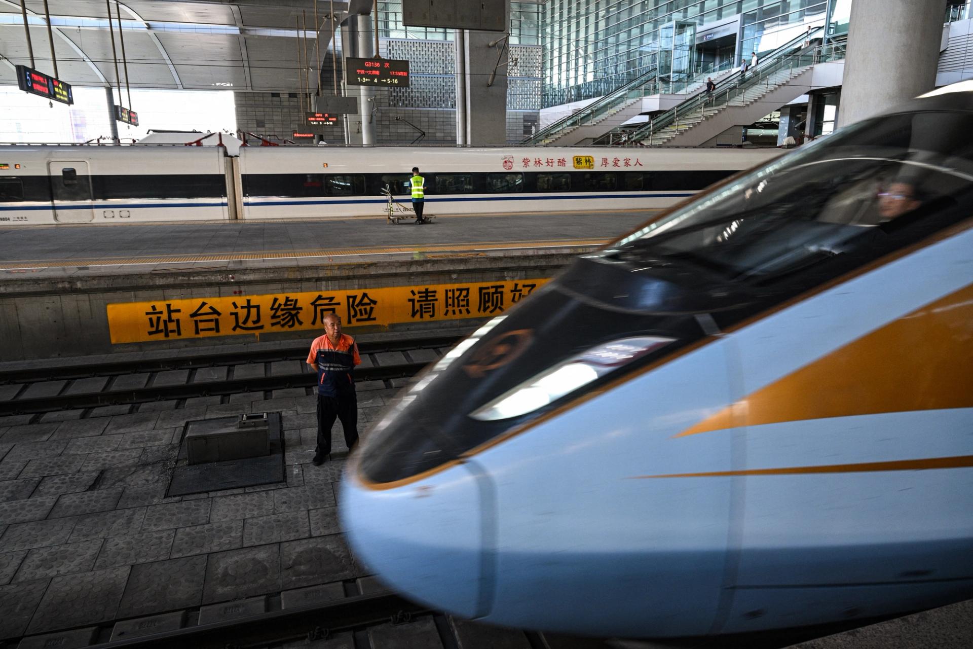 A worker stands as a train arrives at Taiyuan South Railway Station in Taiyuan, capital of China’s Shanxi province on July 22, 2025. 