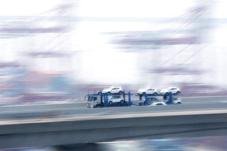 A car carrier transporting vehicles made by Kia Motors,.