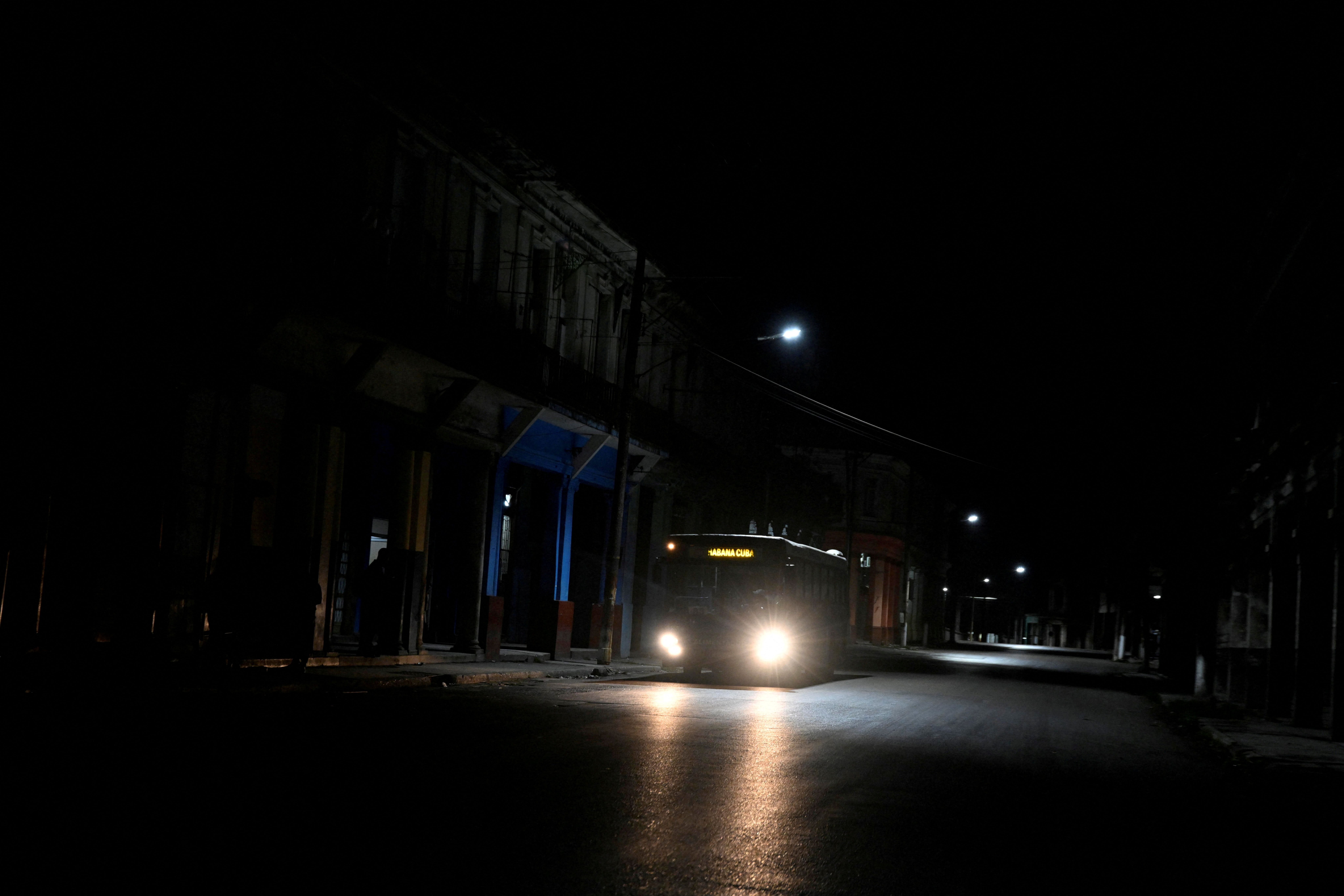 A bus drives along a dark street as Cuba begins efforts to restore power after its grid collapsed for the second time in a week amid a U.S. oil blockade that has dealt a major blow to the island’s already ailing energy infrastructure, in Havana