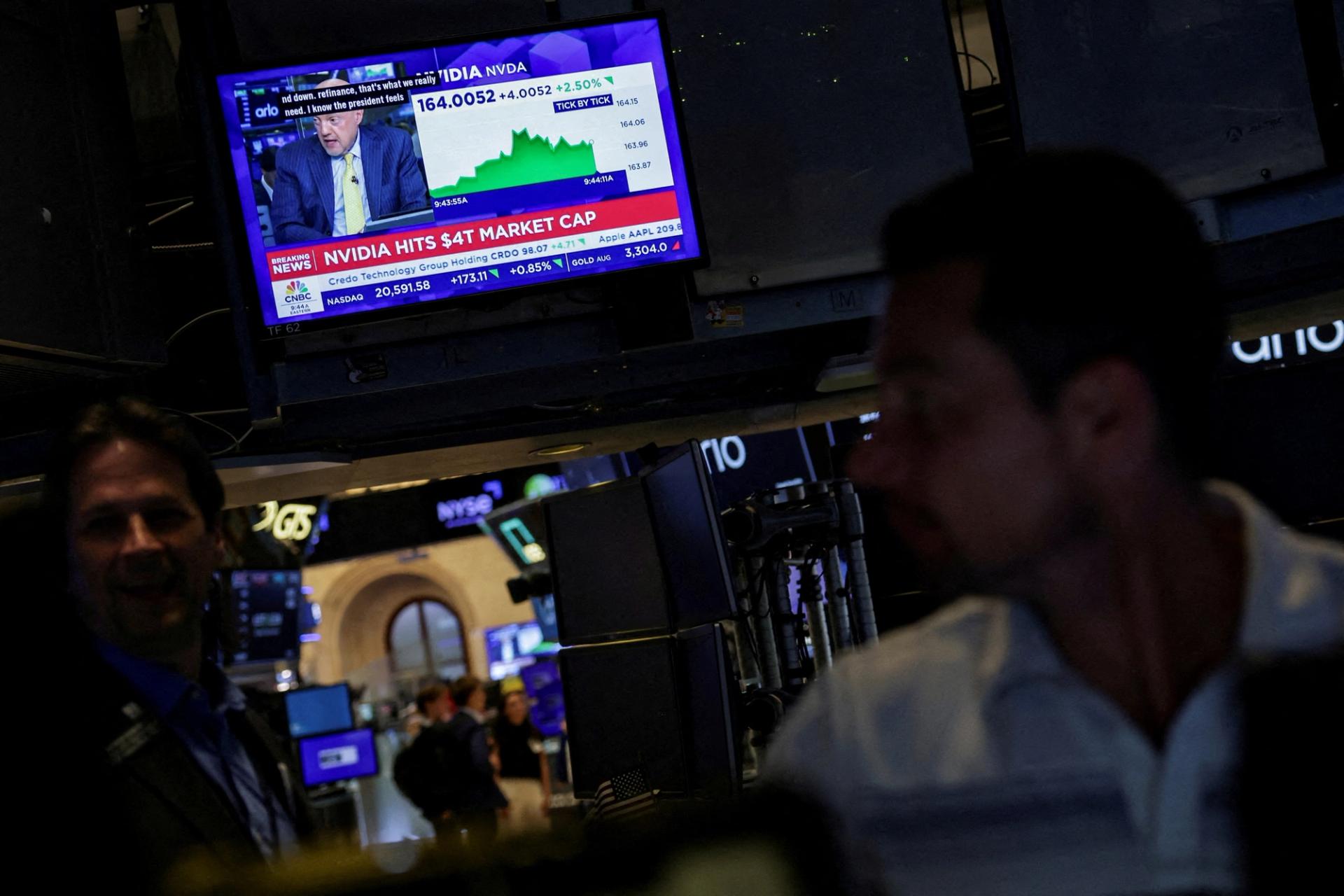 A screen displays news on “Nvidia hits $4T market cap” on the floor at the New York Stock Exchange.