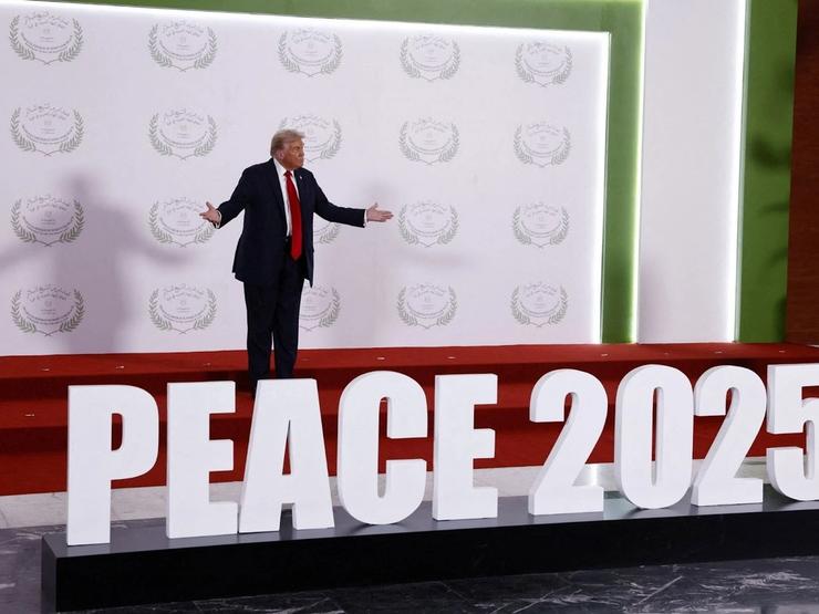 US President Donald Trump waits to greet world leaders before a family photo at a world leaders’ summit on ending the Gaza war.