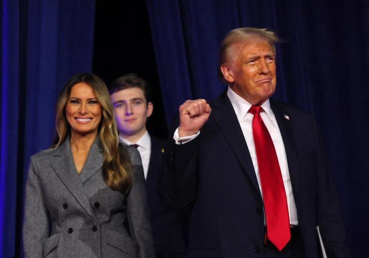 Republican presidential nominee and former US President Donald Trump takes the stage with his wife Melania to address supporters at his rally, at the Palm Beach County Convention Center