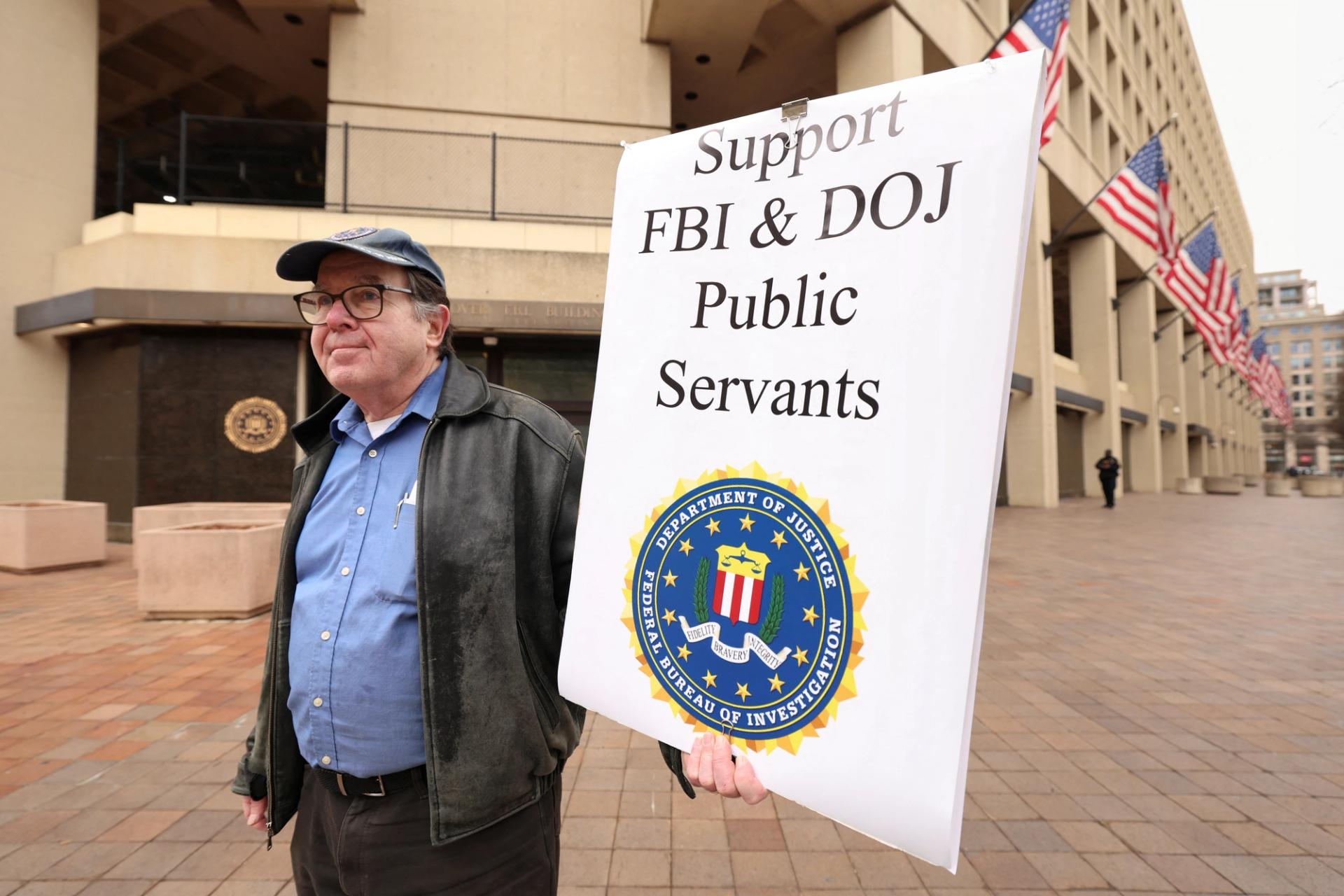 Stephen Butterfield of D.C. holds a sign outside the FBI headquarters showing his support for the FBI and Department of Justice employees.