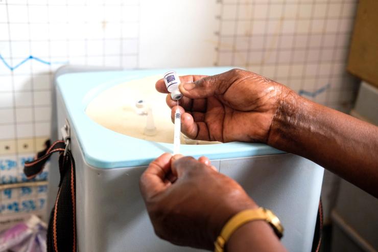 A nurse prepares a syringe by drawing a dose of malaria vaccine in Uganda.